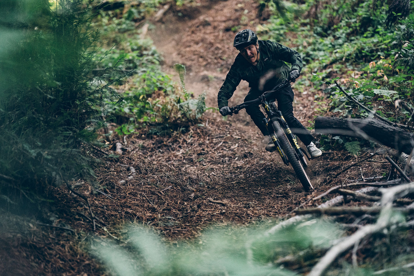 Person mountain biking on a trail in a forest