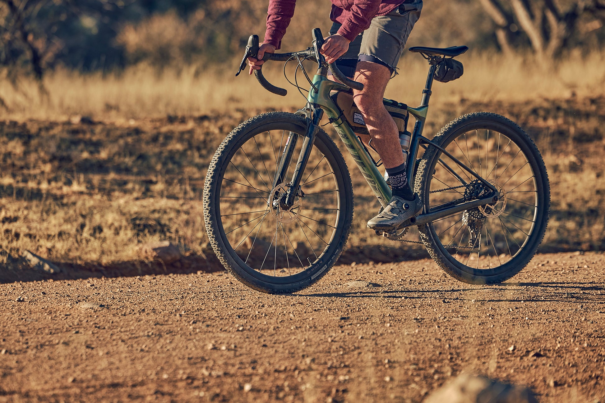 Person riding a bicycle on a dirt road with a blurred background