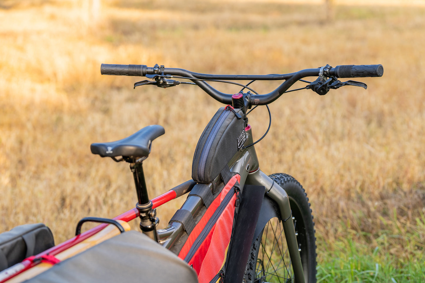 Bicycle with red frame and black seat in a field