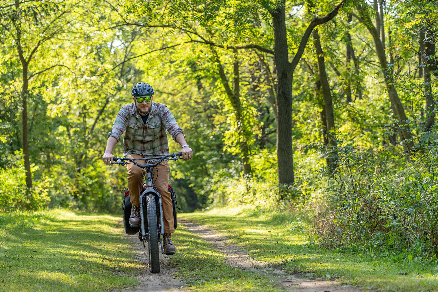 Person riding a bicycle on a trail through a forest
