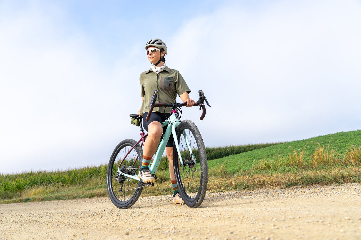Person riding a bicycle on a dirt path with a scenic background