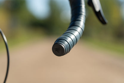 Close-up of a bicycle handlebar with blurred natural background