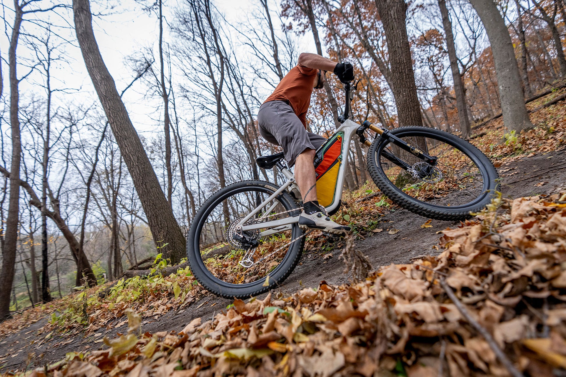 Mountain biker climbing trail out of saddle with seatpost down