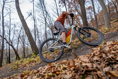 Mountain biker climbing trail out of saddle with seatpost down