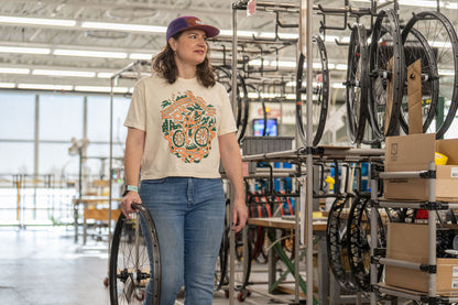 Person in a factory setting with bicycle wheels and parts around