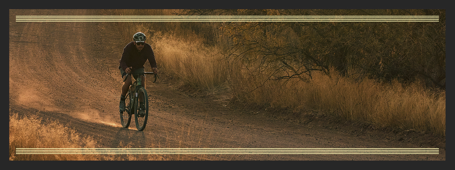 Cyclist riding drop bar bike on gravel road on sunny day