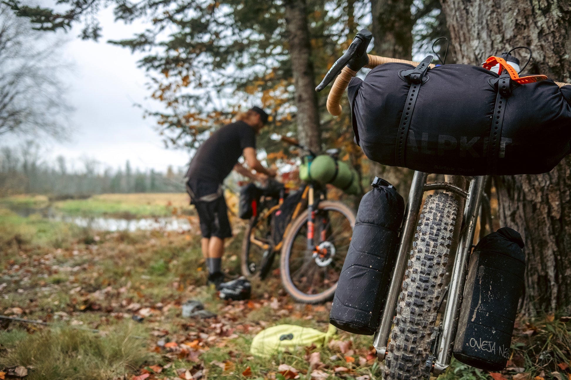 Person with a bicycle and gear in a forest setting