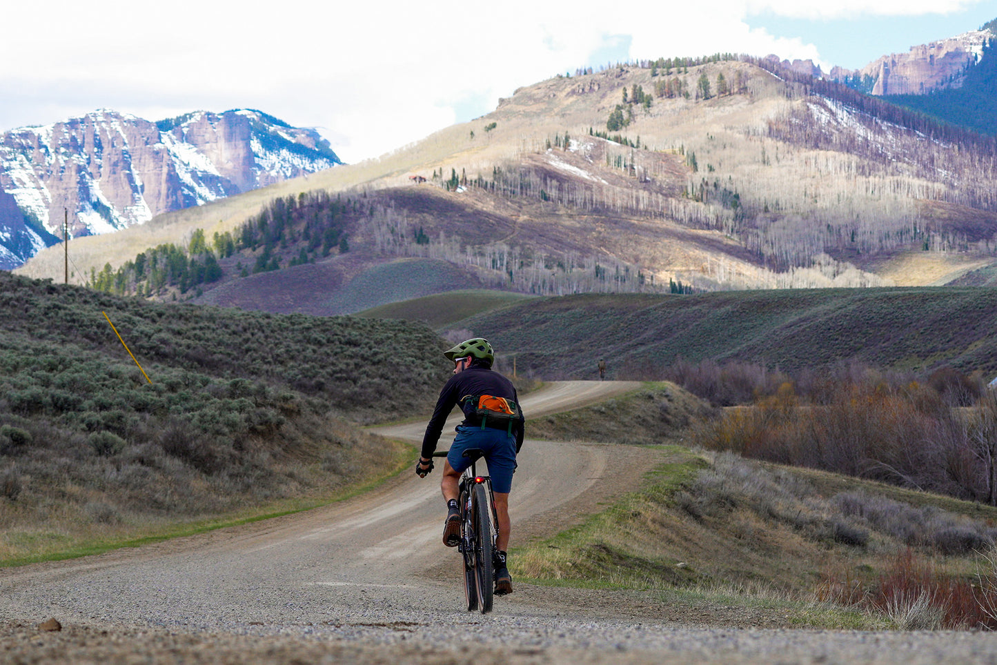 Cyclist riding gravel road in mountains