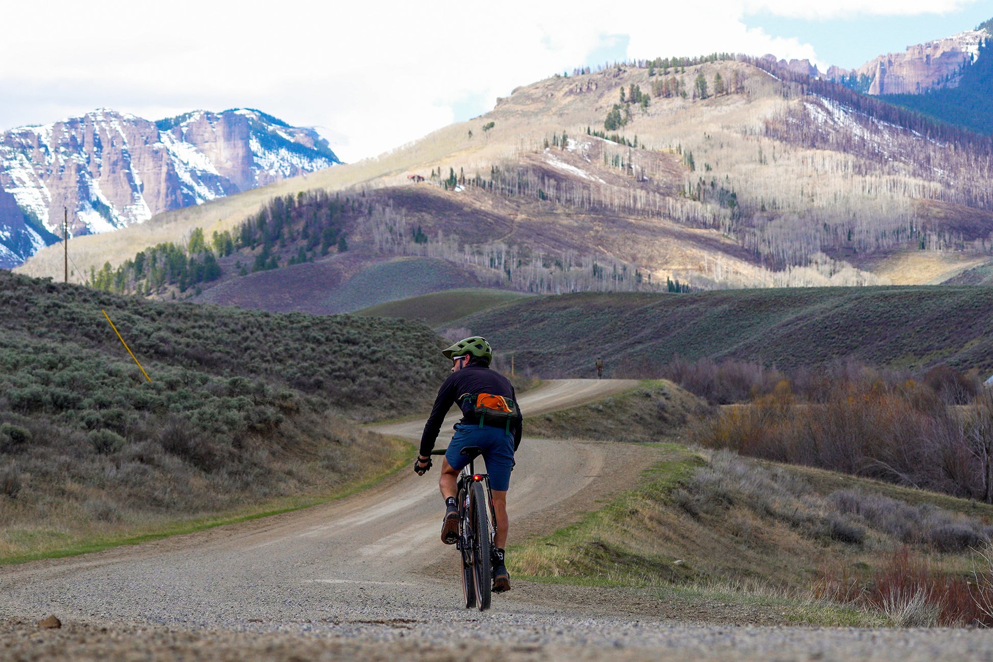 Cyclist riding gravel road in mountains