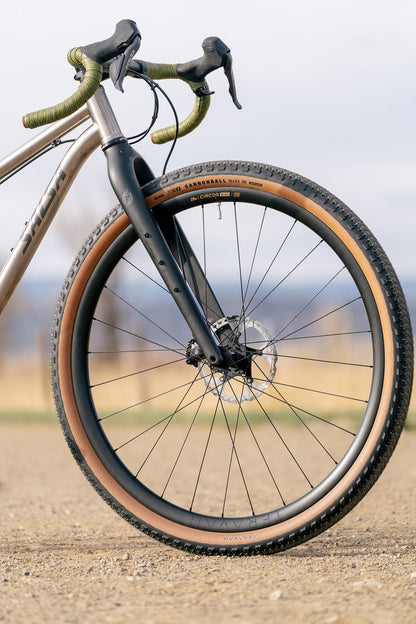 Teravail Cannonball 32 Tire tan sidewall on front wheel of Salsa bike on gravel road