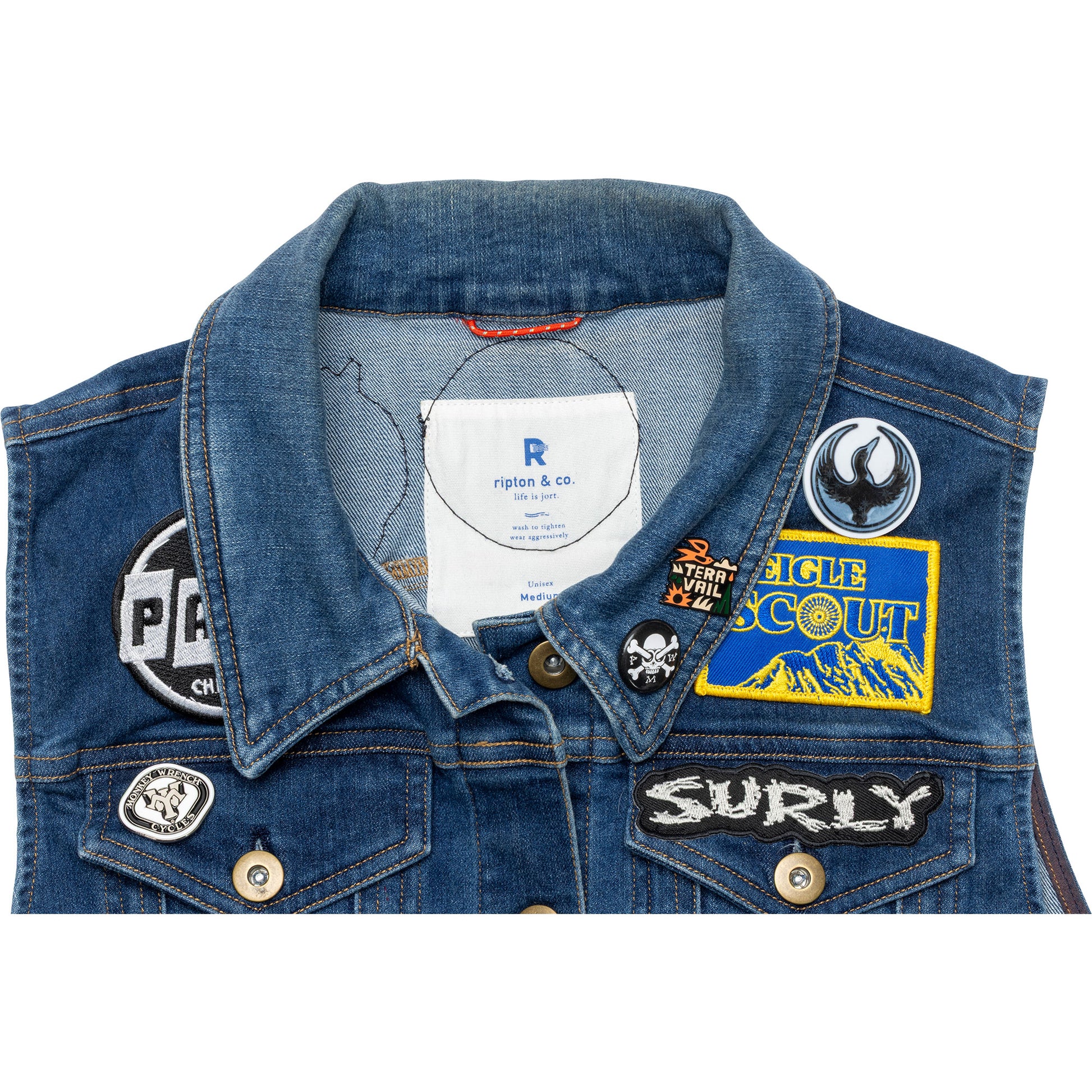 Blue denim jacket with various patches on a white background