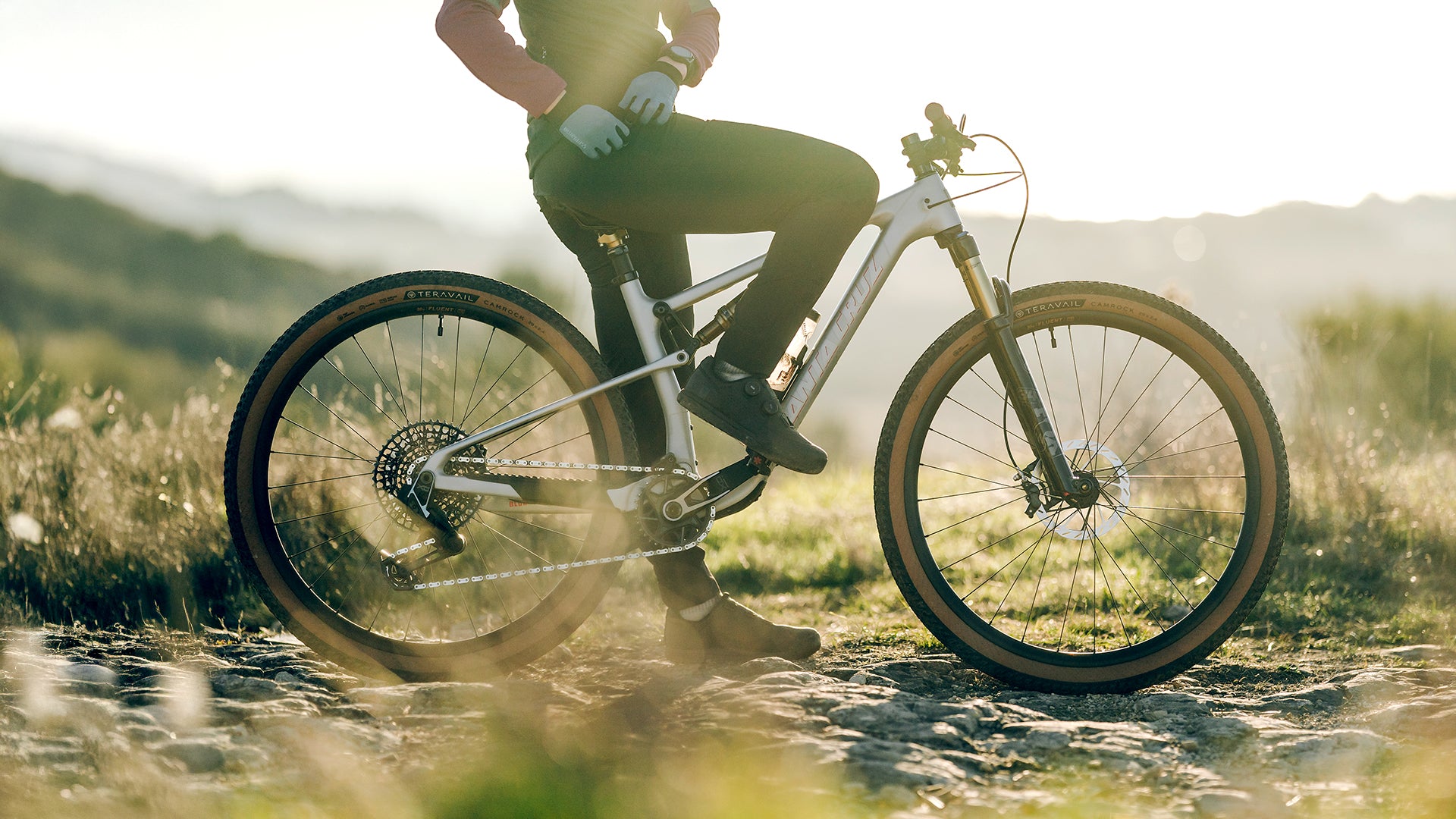 Mountain biker stopped with foot down trail side showing Teravail Camrock tires