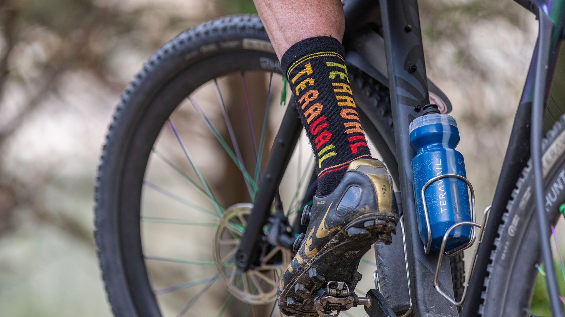 Cyclist standing over bike one foot clipped in wearing Teravail socks